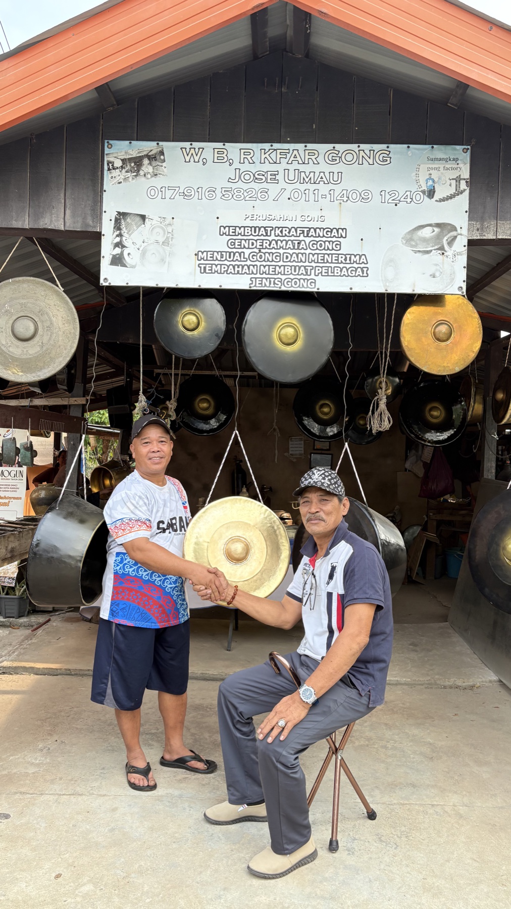 Two gong makers photographed with a gong